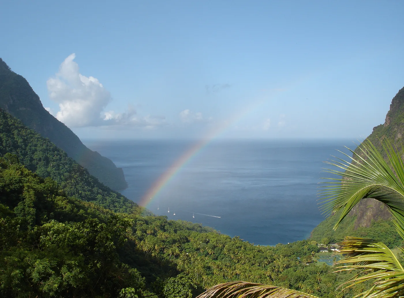 A rainbow over the sea seen from the forested valley between the Pitons, Saint Lucia